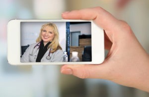 Hand holding smart mobile phone on light blurred background